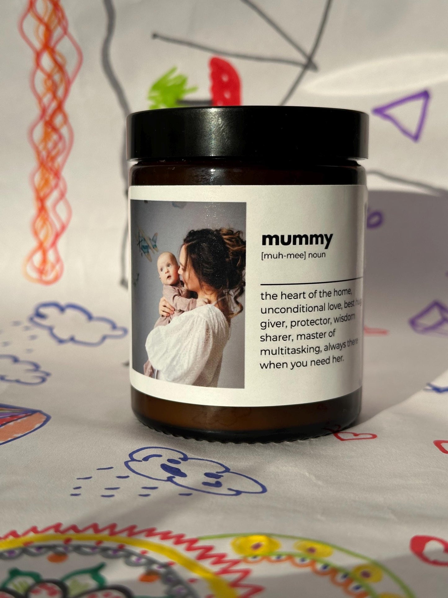 Amber glass candle with the sticker with photo and dictionary style text about mummy